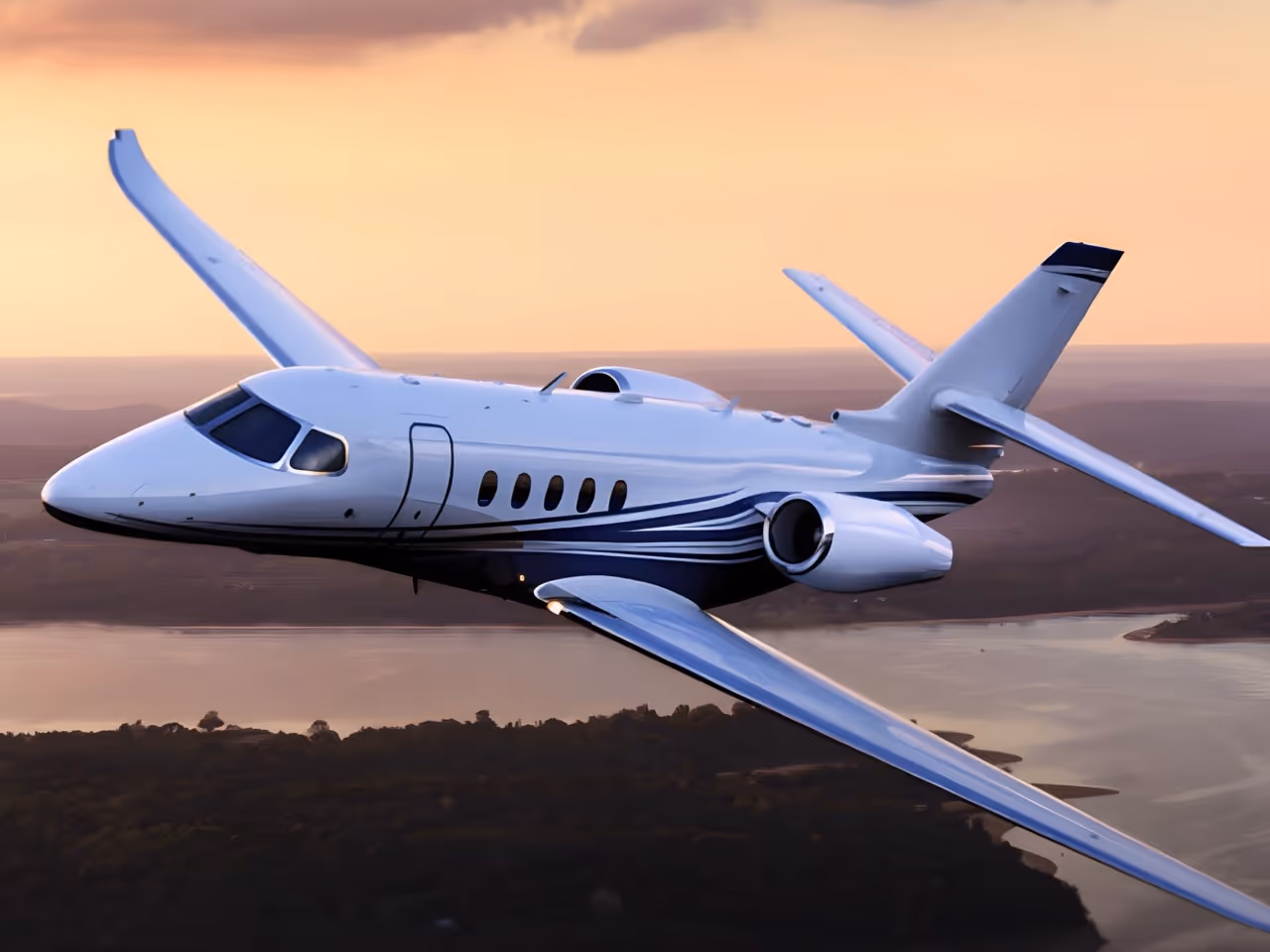 Jet privato a noleggio bianco con strisce blu che sorvolano il fiume e la foresta al tramonto.