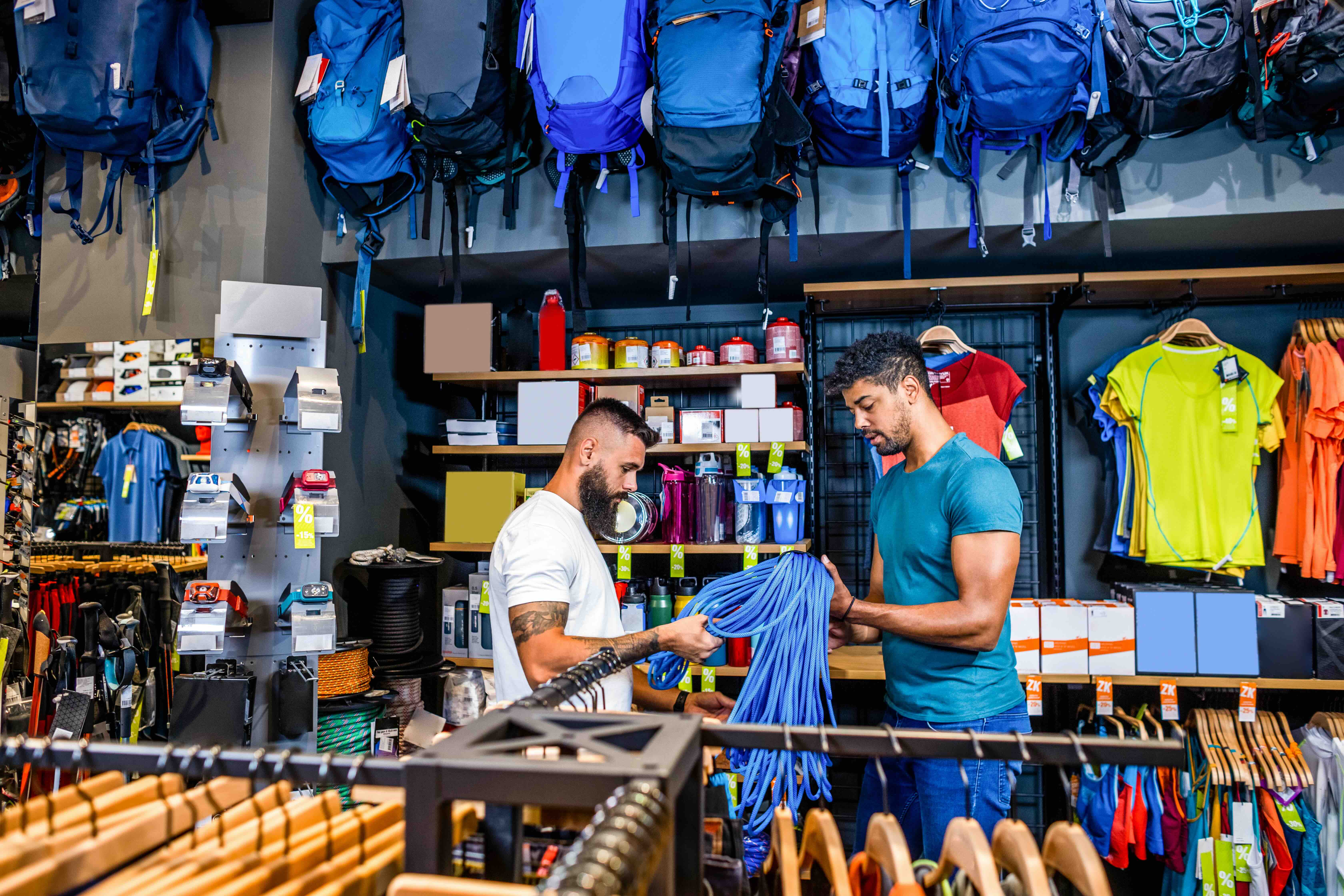 Staff member assisting a customer in a sports and outdoor equipment retail store