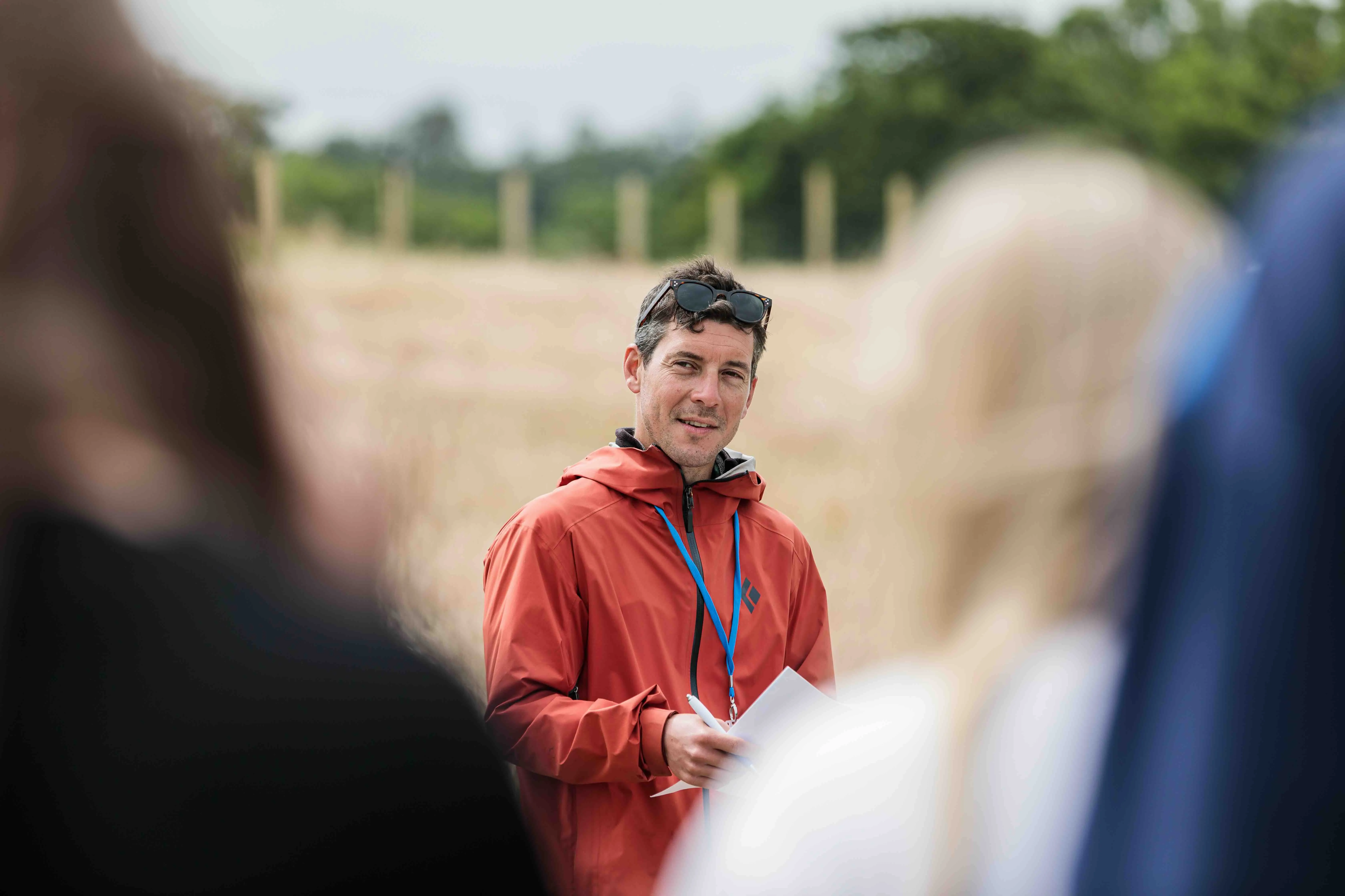 An apprentice with a mentor in an outdoor field setting during a skills training session