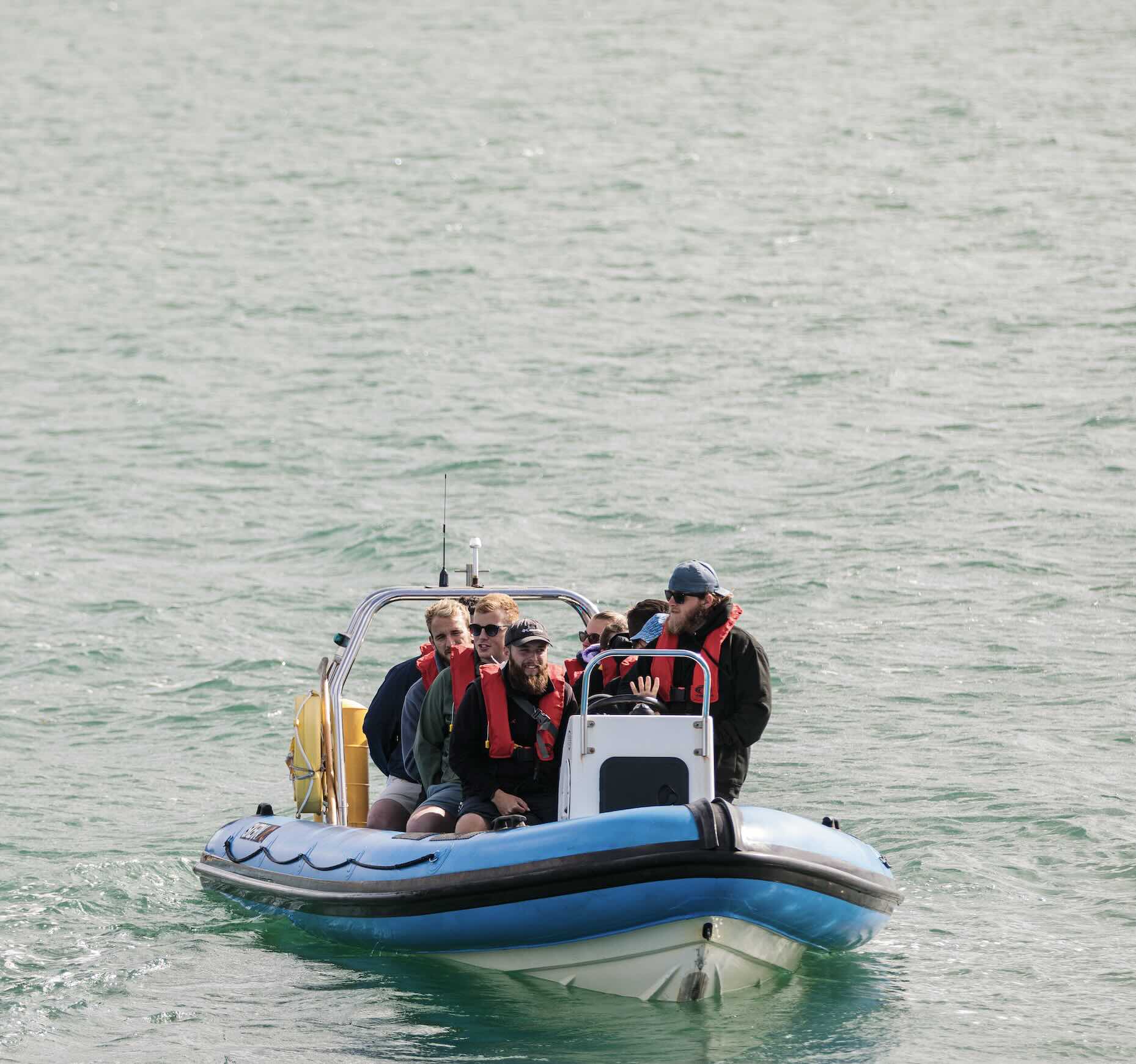 A group of people enjoying a boat activity on the water during an outdoor training programme