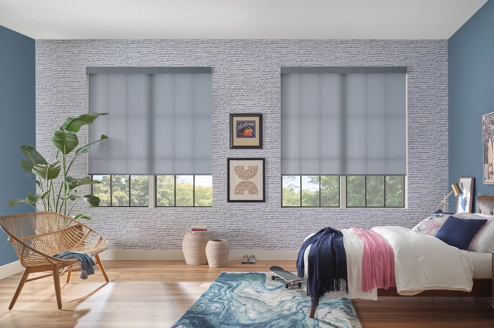 Grey roller shades partly lowered over two bedroom windows in a blue kids room