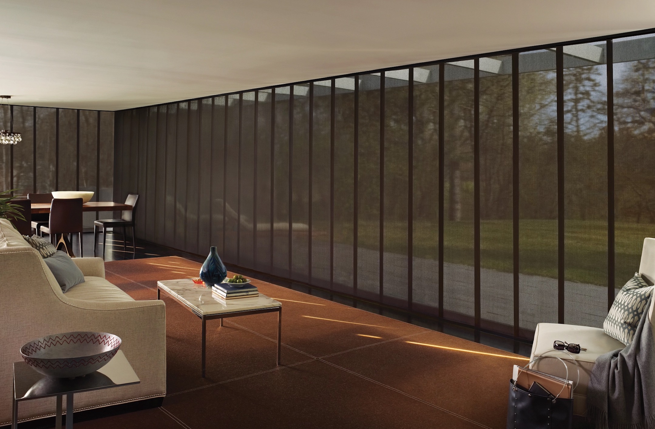 Dark sheer sliding panel shades covering a floor-to-ceiling glass wall in a living and dining space