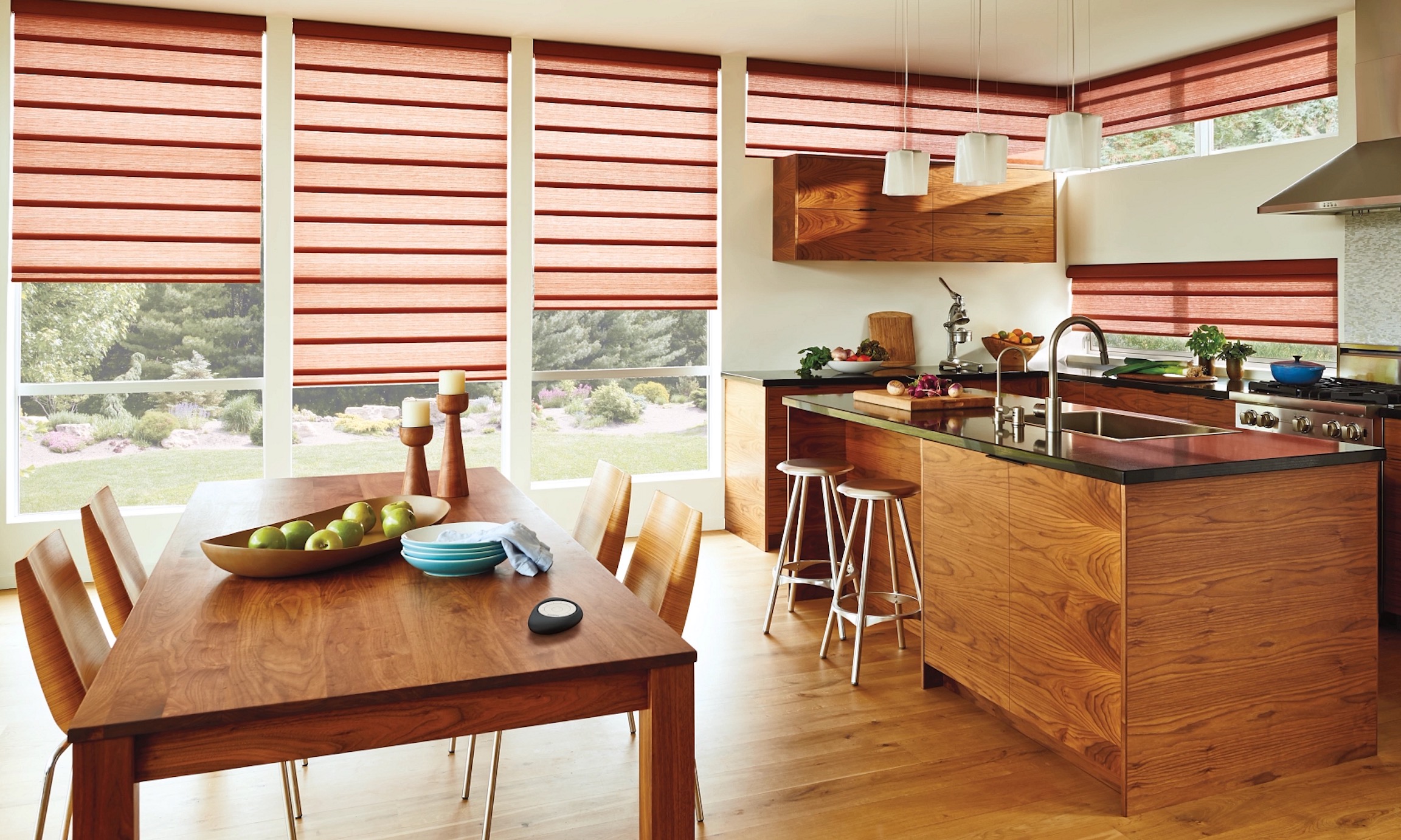 Rust-red Roman shades across kitchen and dining room windows in a walnut-toned open kitchen