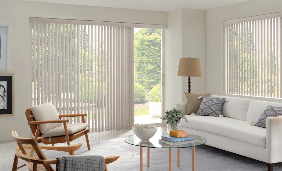Cream vertical blinds on a sliding glass patio door and side window in a bright living room