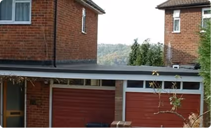 Flat EPDM rubber roof covering a double garage attached to a brick house.