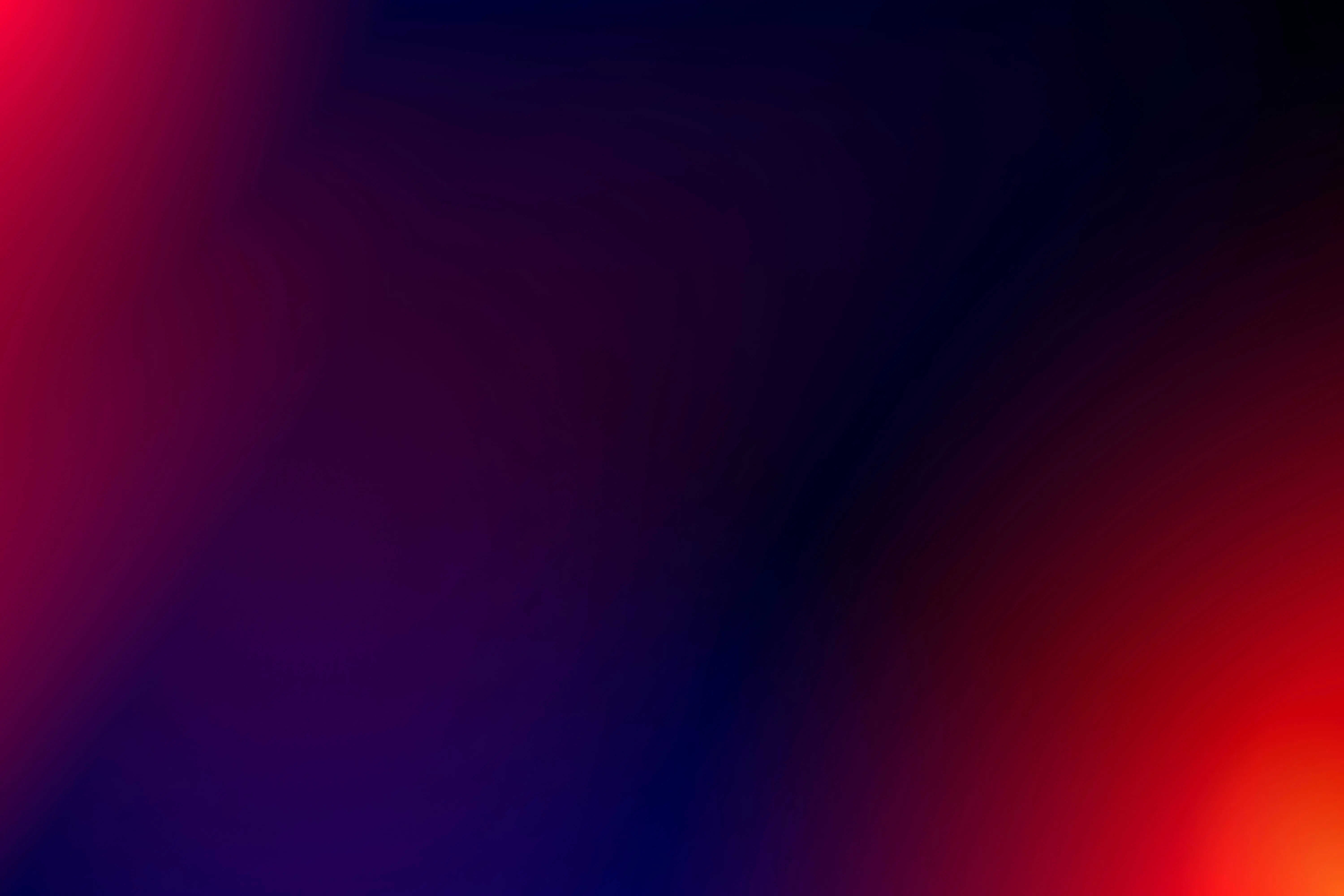 Abstract blurred gradient background with smooth dark purple, red, and orange color transitions.