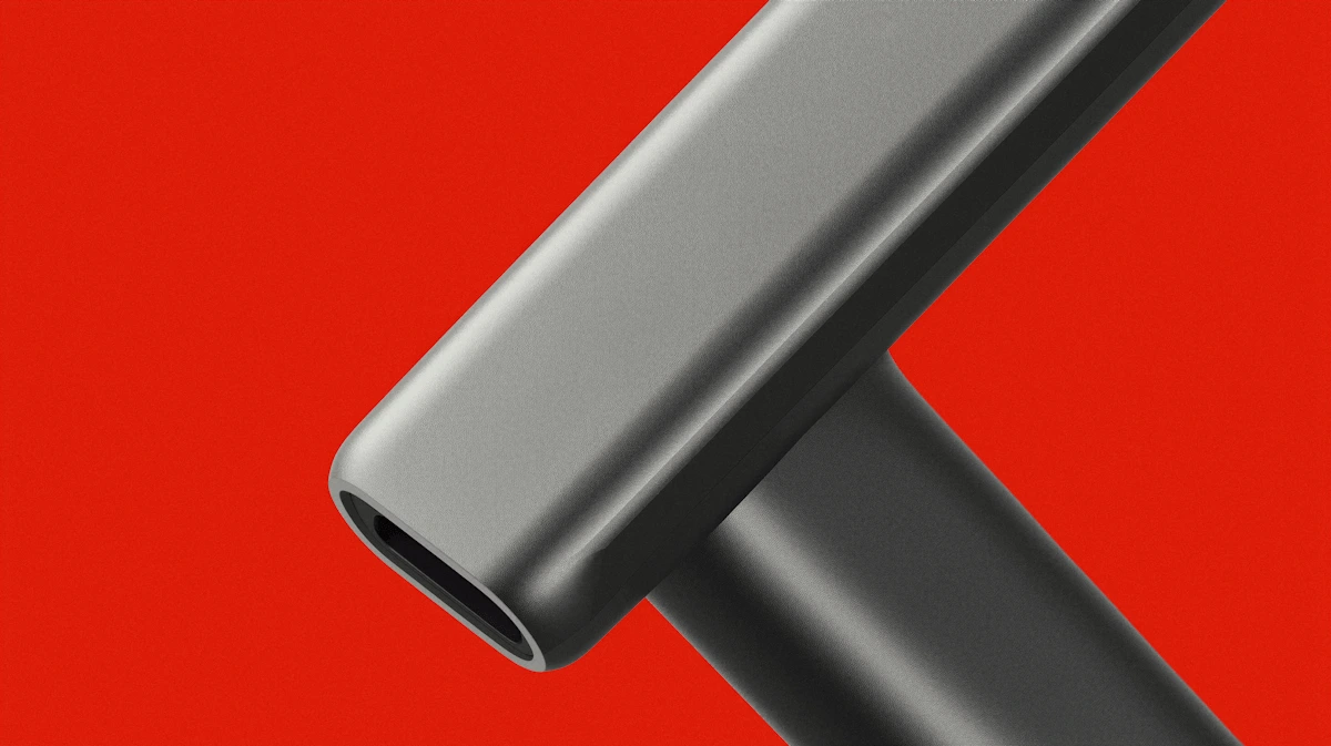 Close-up of intertwined sleek metallic tubes with a smooth matte finish on a bright red background.