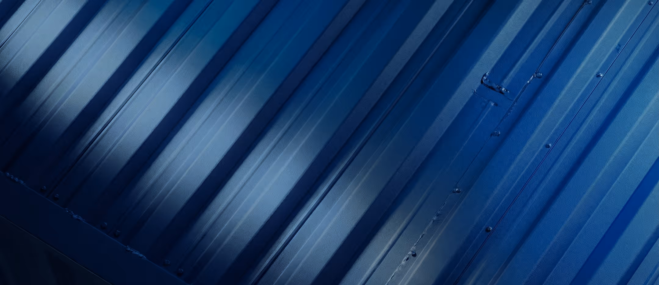 Close-up of blue corrugated metal surface with vertical ridges and rivets.