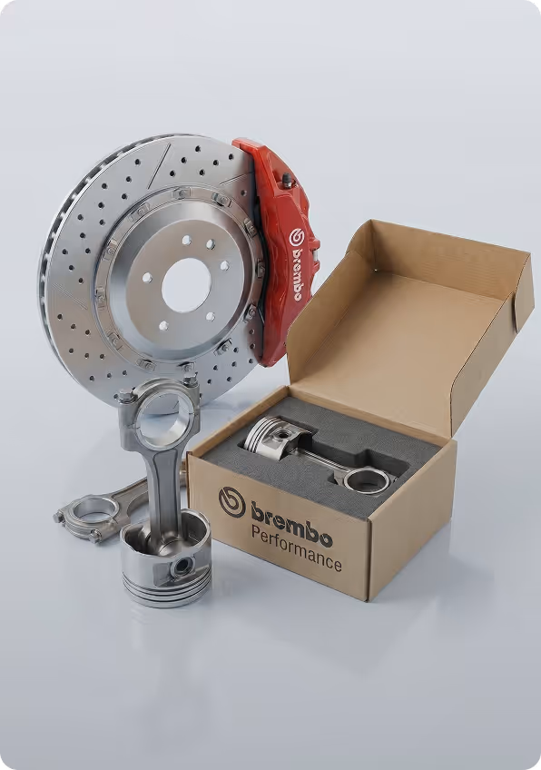 Brembo performance brake disc with red caliper and two piston connecting rods, one inside a Brembo Performance box.