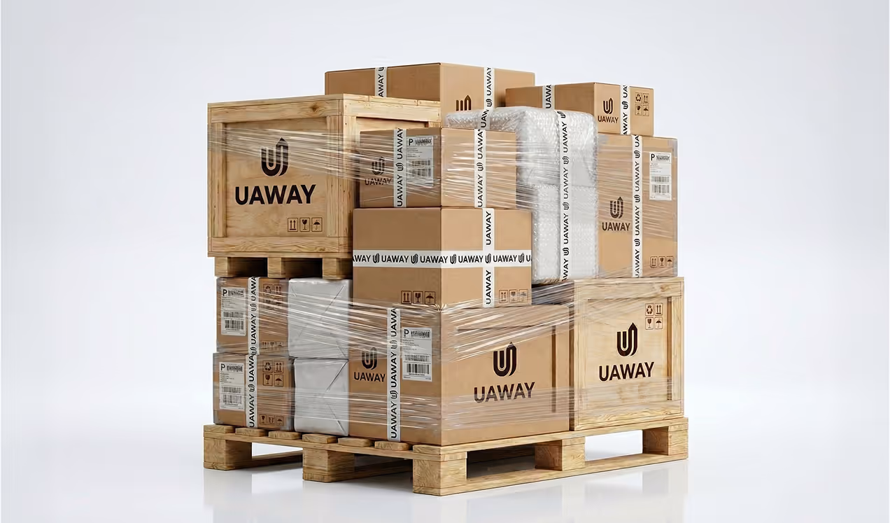 Wooden pallet stacked with various cardboard and wooden boxes labeled UAWAY, wrapped in clear plastic wrap.