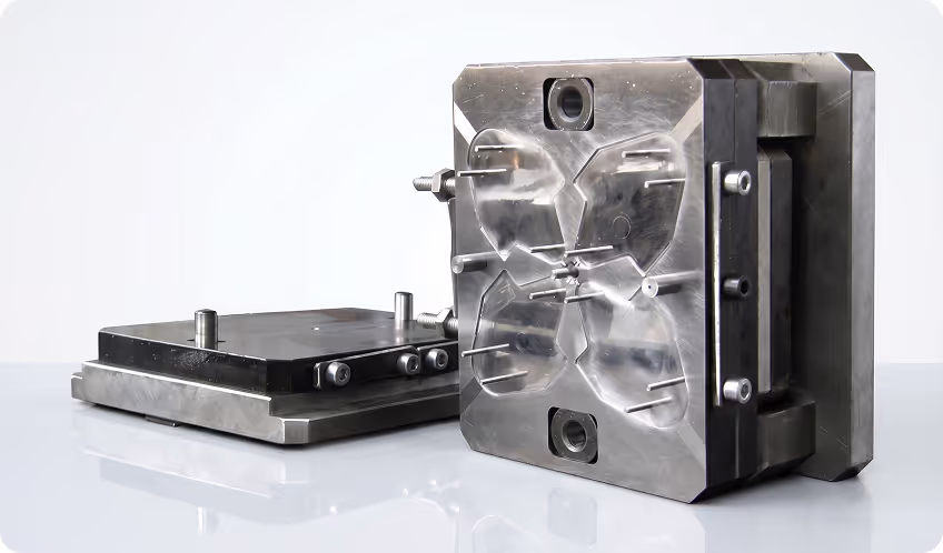 Two-piece metal injection mold tool with cavity and core plates used in manufacturing.