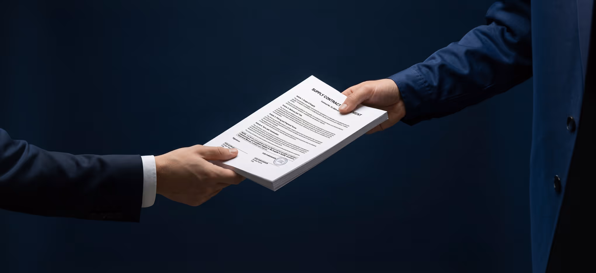 Two people exchanging a stack of supply contract documents against a dark background.