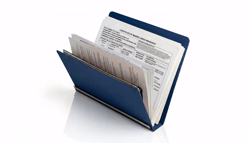 Blue document holder standing open with several stacked papers inside, including a visible Certificate of Marine Cargo Insurance.