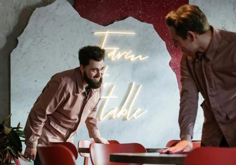 Two waiters working together to clean tables