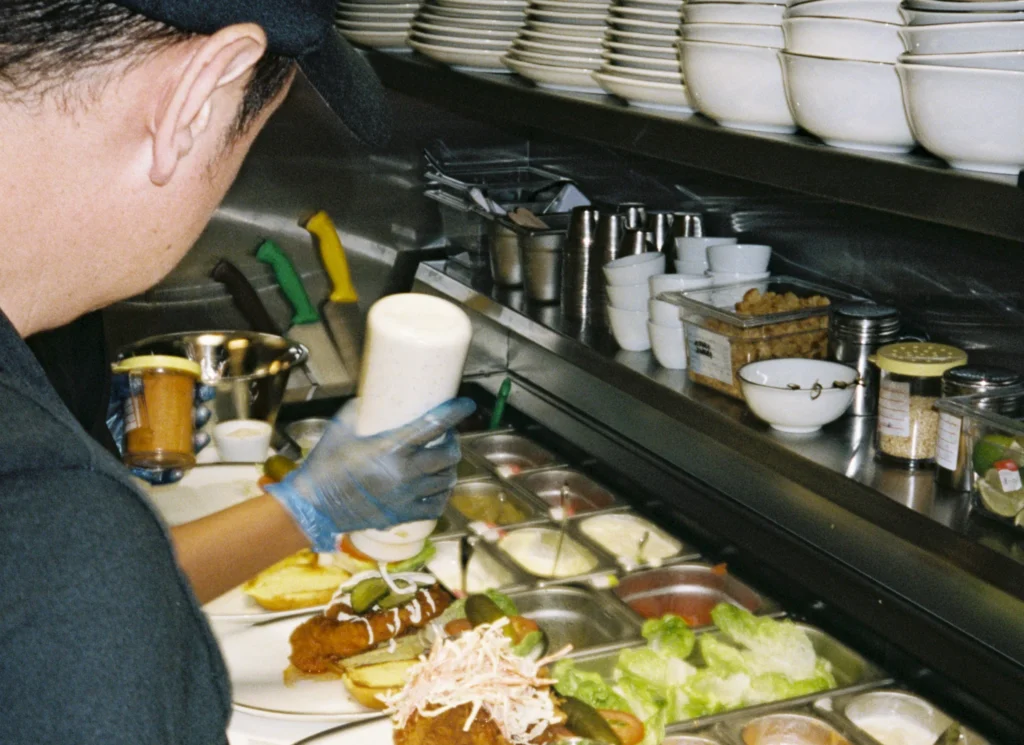Restaurant operator watching employee plate food