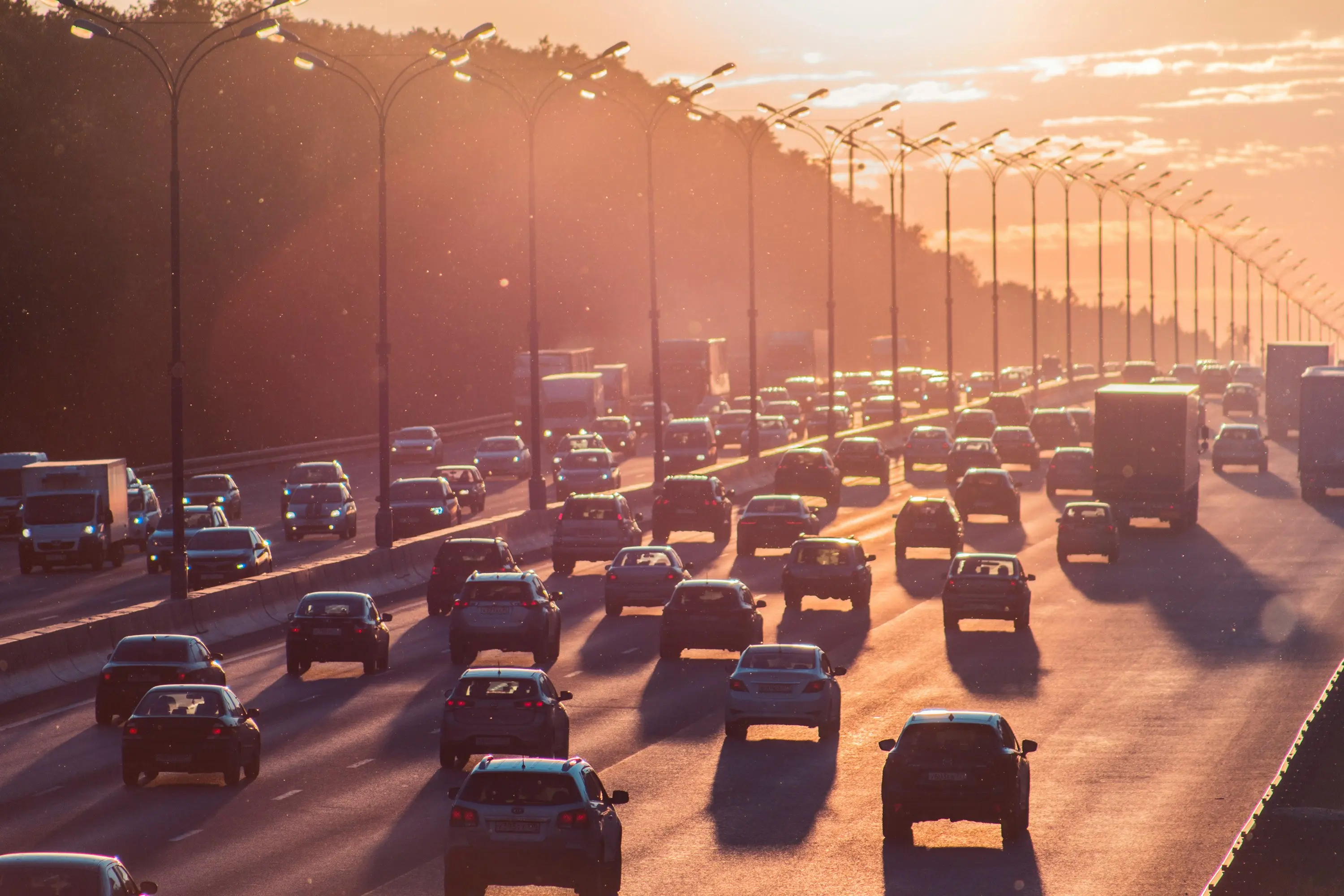 Heavy traffic on a Los Angeles highway during golden hour, with cars and trucks moving through rush hour congestion.