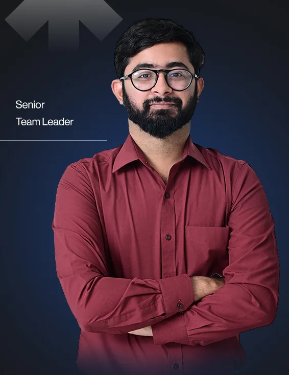 Man with glasses and beard wearing a maroon button-up shirt, standing with arms crossed, labeled Senior Team Leader.