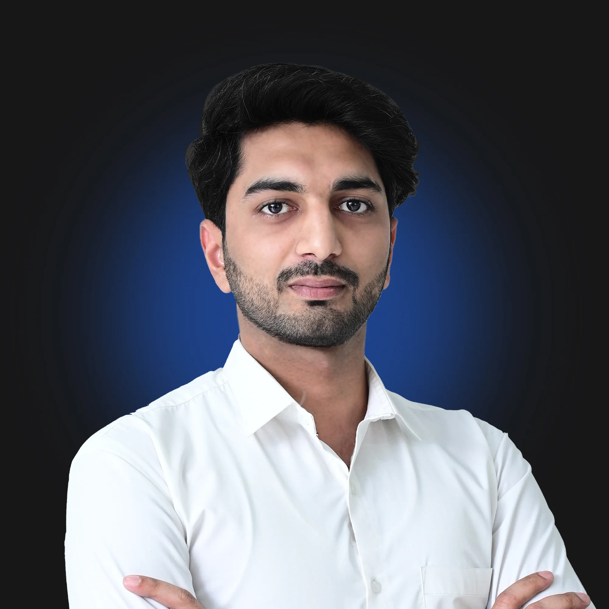 Confident young man with folded arms wearing a white shirt against a dark blue background.