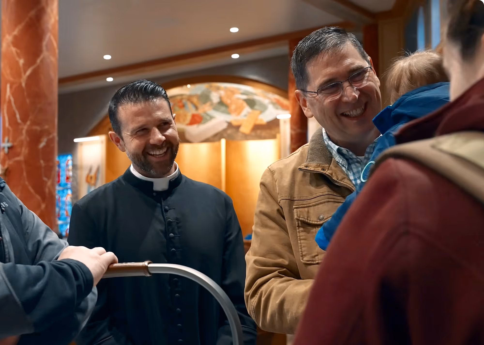 Smiling Priest talking to family