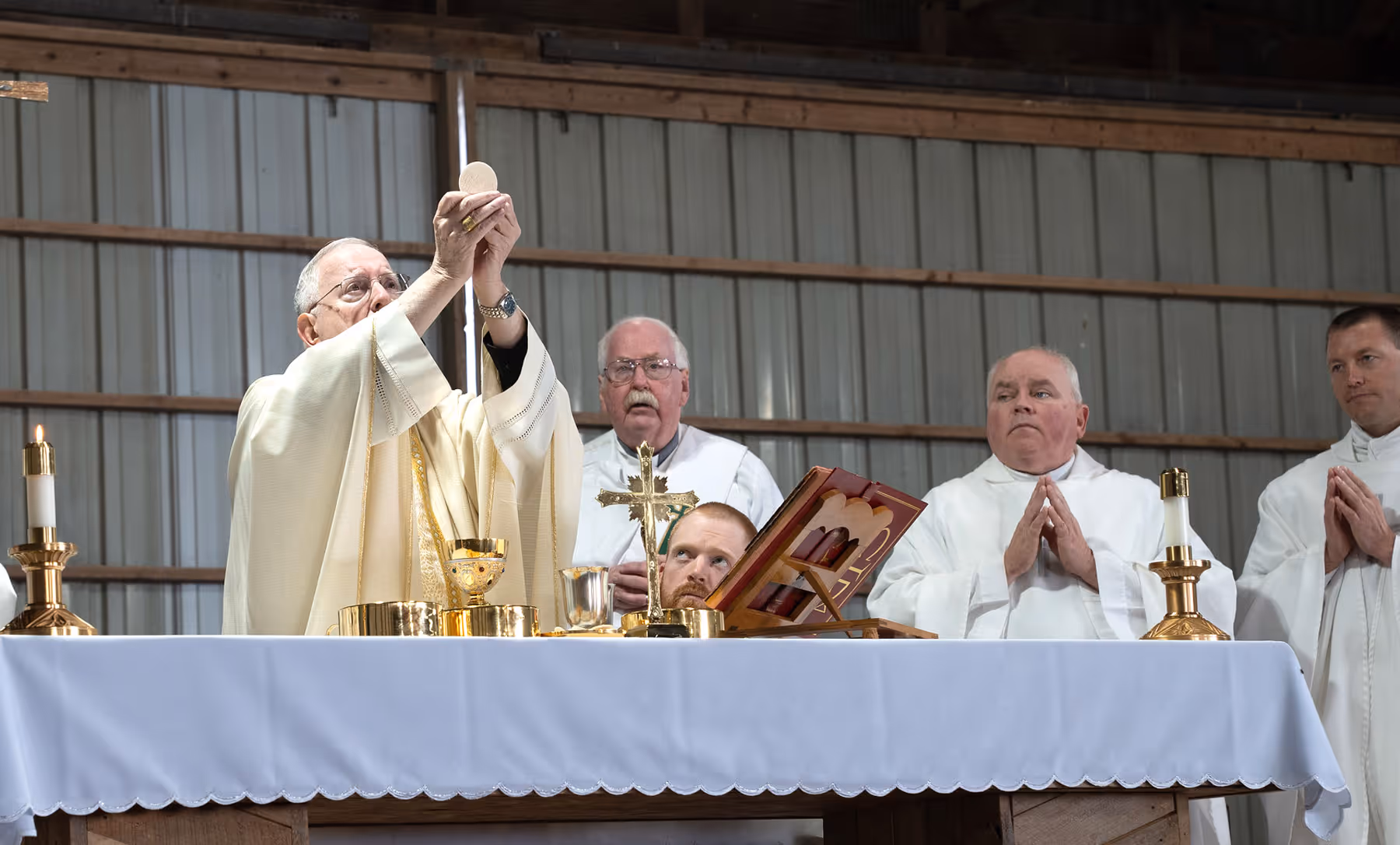 Priest lifting up the Eucharist during Mass