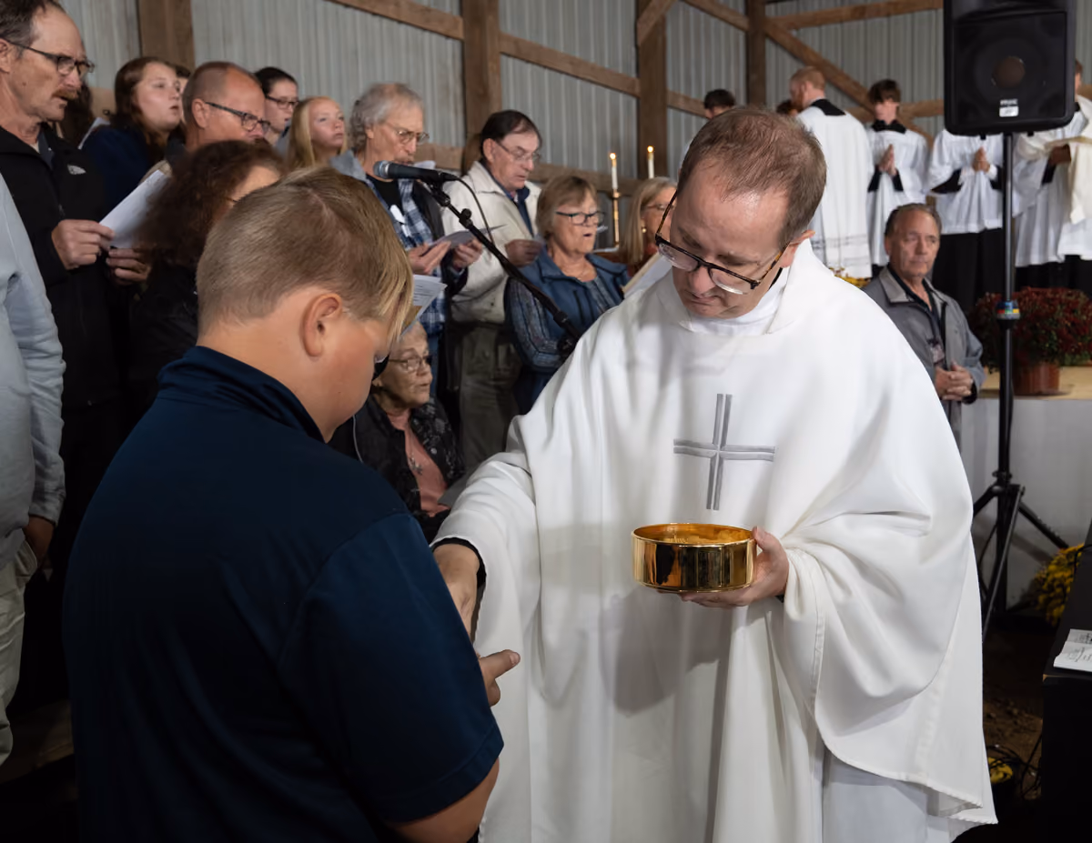 Priest giving the Eucharist to boy at Mass