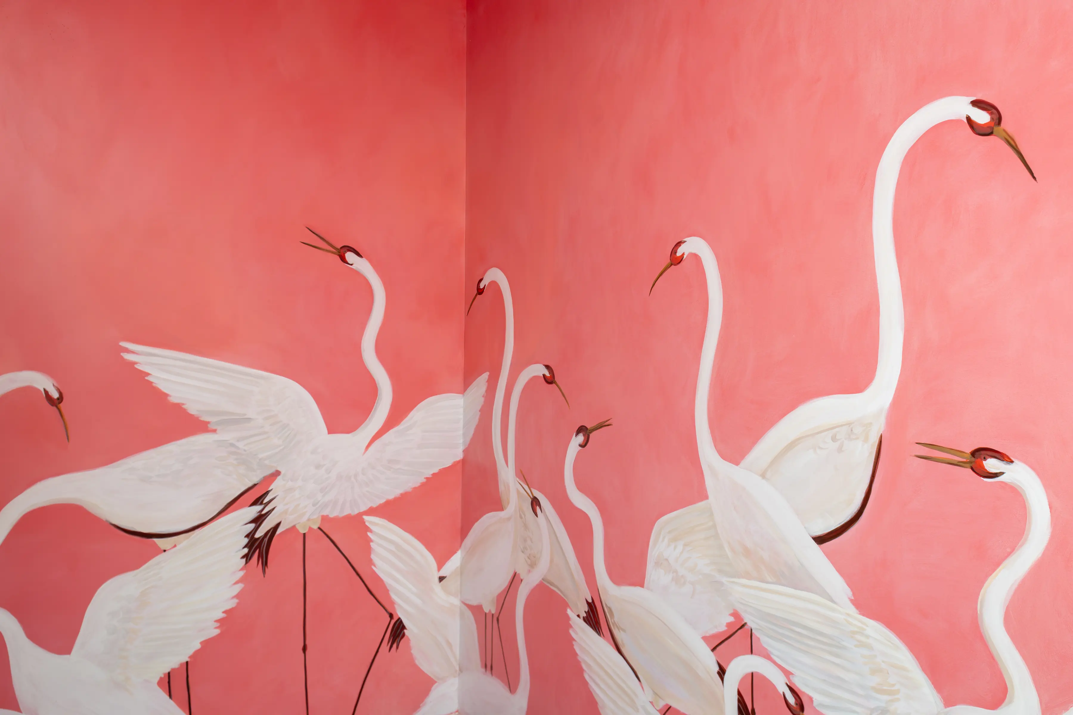 Painting of white cranes with long necks and wings against a pink wall corner.