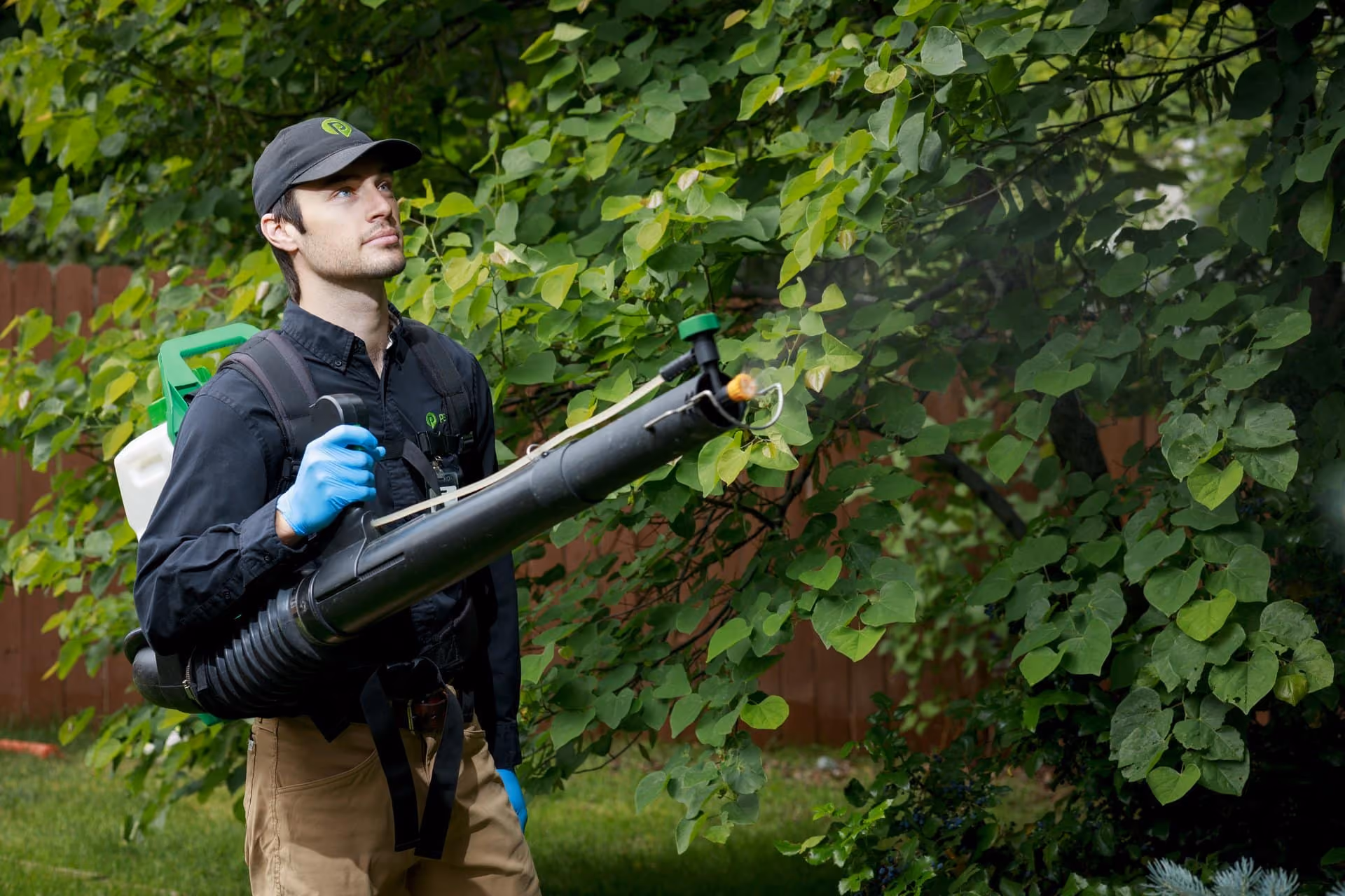Pest Pro technician performing pest control service in a Utah yard