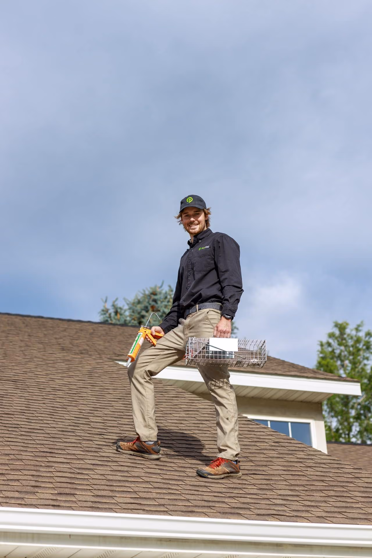 Pest Pro technician on a roof with a trap for squirrel removal in Utah