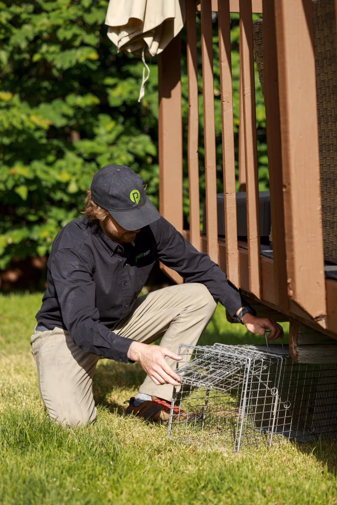Pest Pro technician providing wildlife control service by a backyard deck in Utah