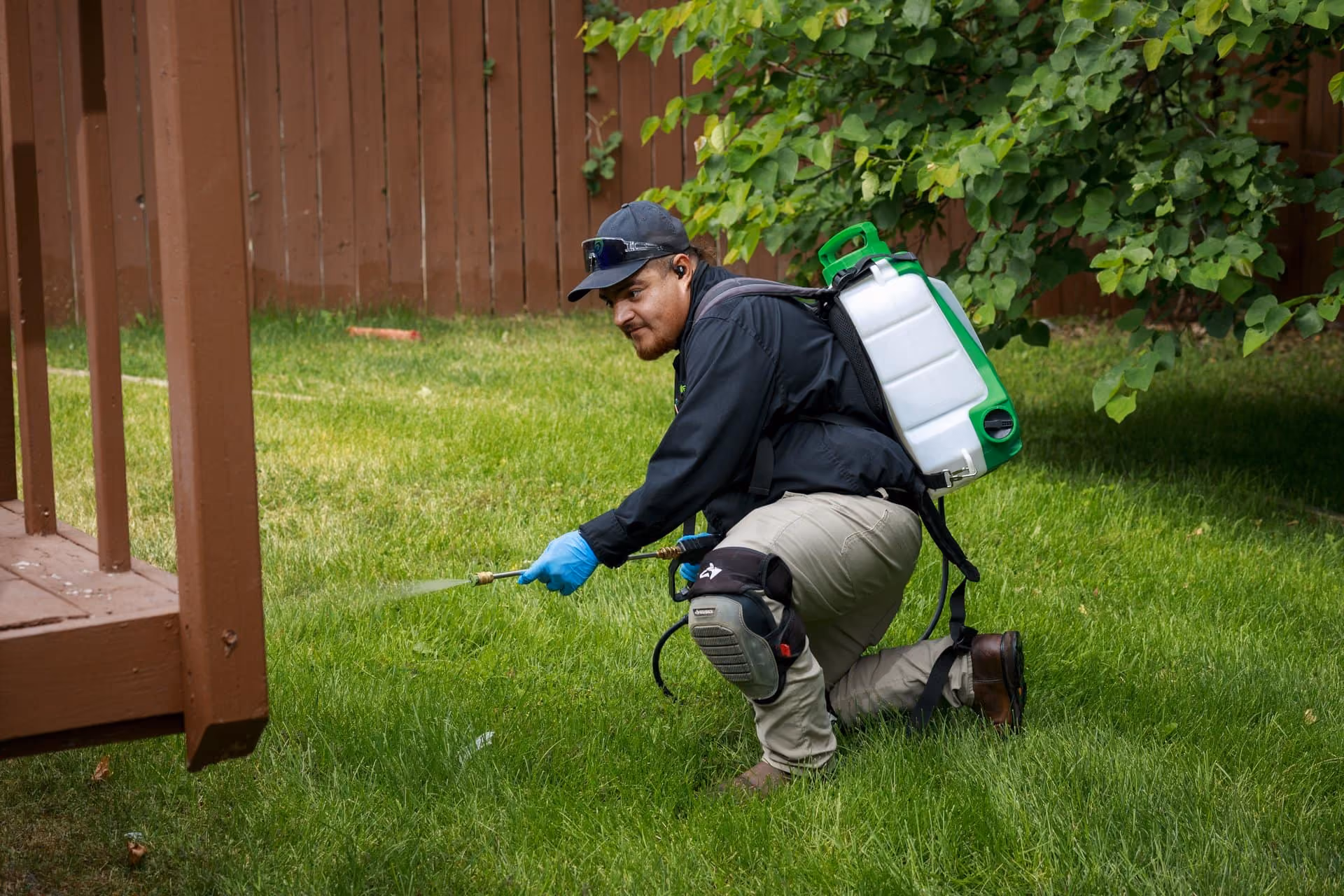 Technician applying general pest control treatment to a lawn in Utah