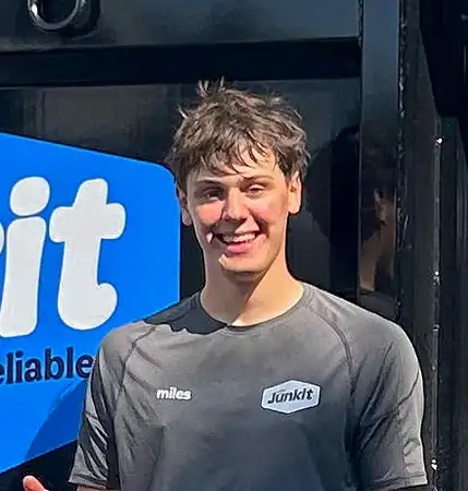 Miles Jordan, owner of Junkit, standing in front of junk removal truck in Charlotte Vermont