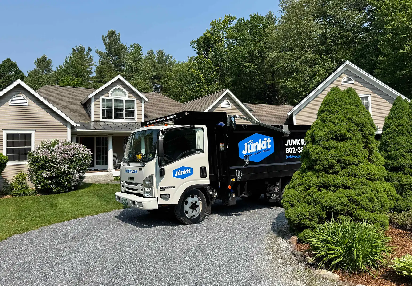 Junkit dump truck parked at residential home for moving cleanout service in Charlotte