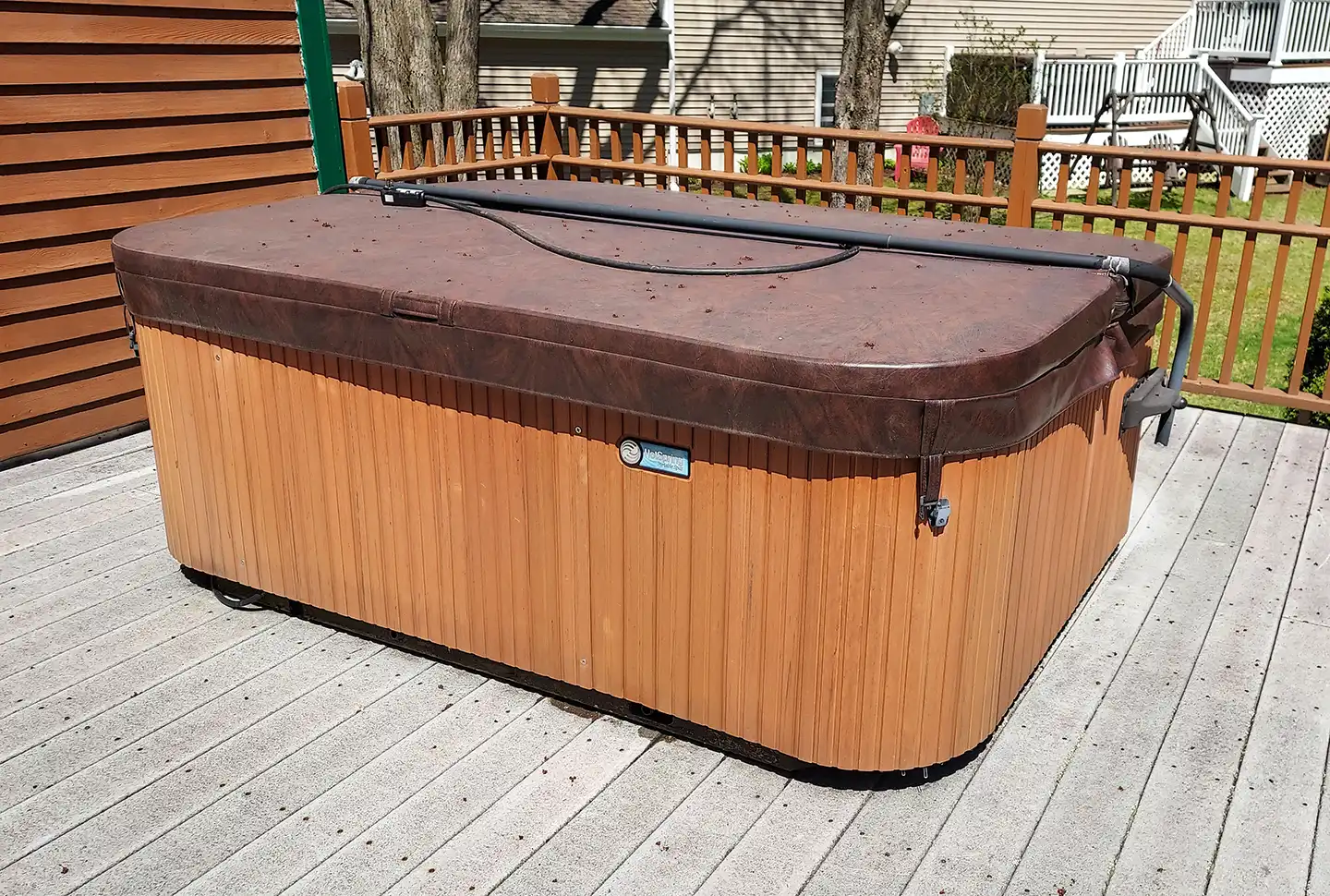 Old outdoor hot tub on deck ready for removal at residential home in Williston Vermont