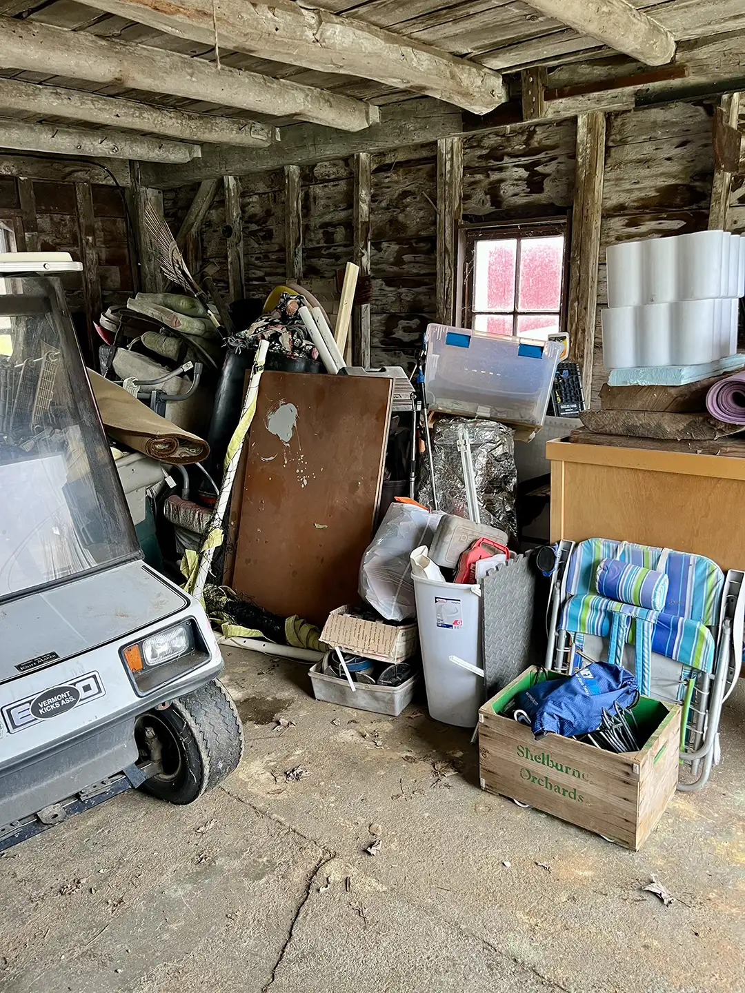 Cluttered garage filled with debris and stored items before cleanout