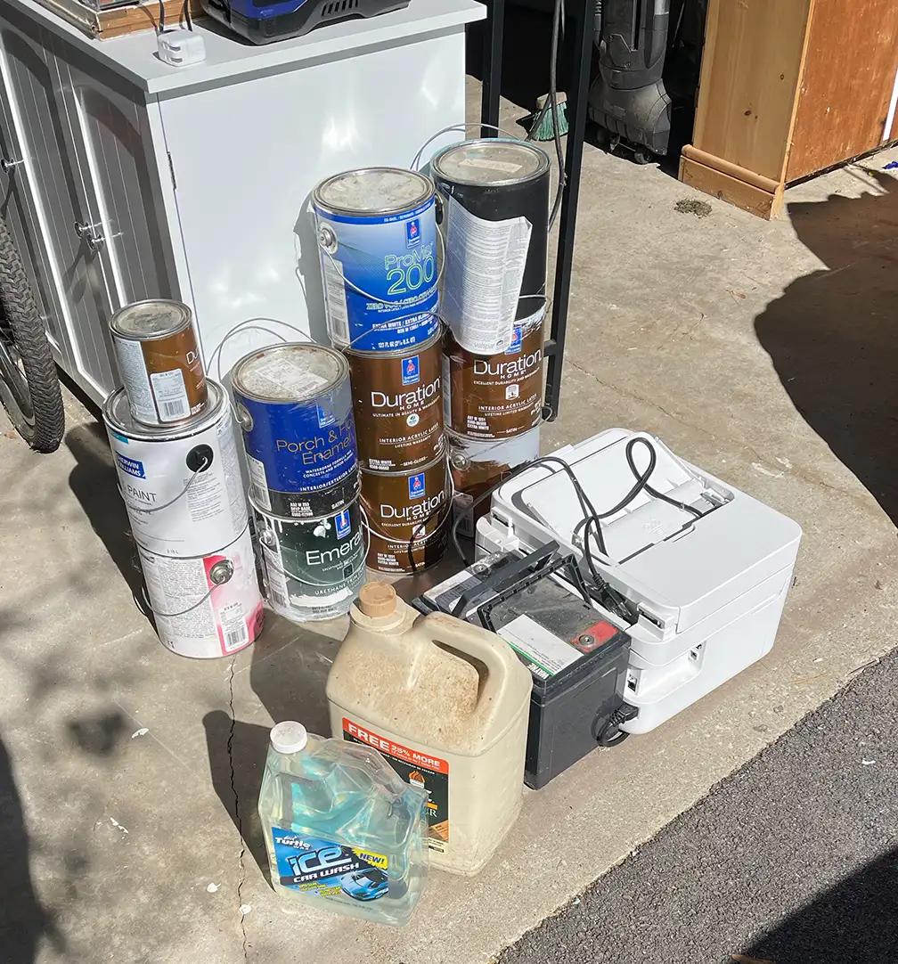 Paint cans, chemicals, and small electronics sorted for proper disposal in Shelburne Vermont
