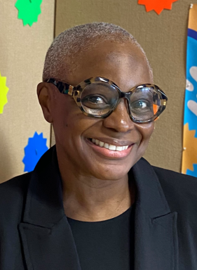 Sandra Kidd smiling in front of colorful classroom decorations