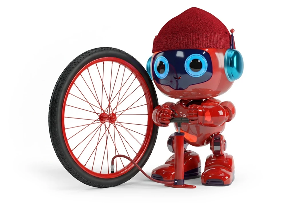 A red robot wearing a red knit cap and blue headphones inflating a large bicycle wheel with a hand pump.