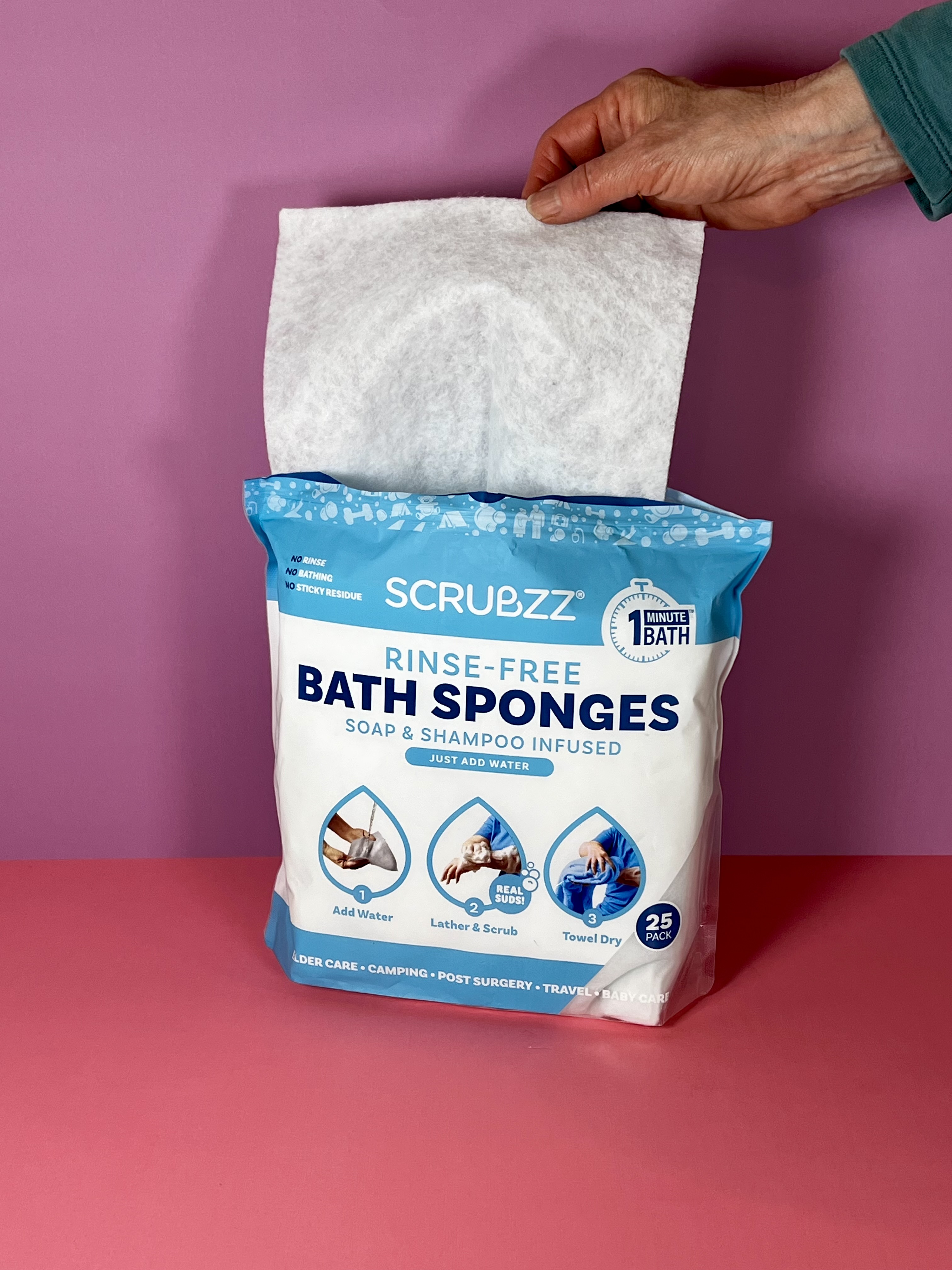 A hand is pulling a dry sheet out of a bag which reads "Bath Sponges." 