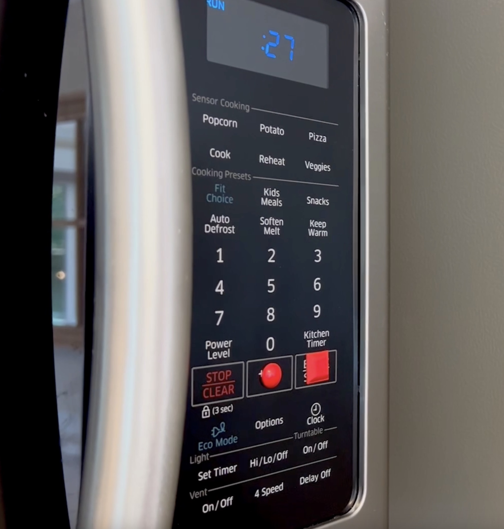 A close-up of a microwave showing a round dot on the +30 seconds button and a square button on the "start" button. 