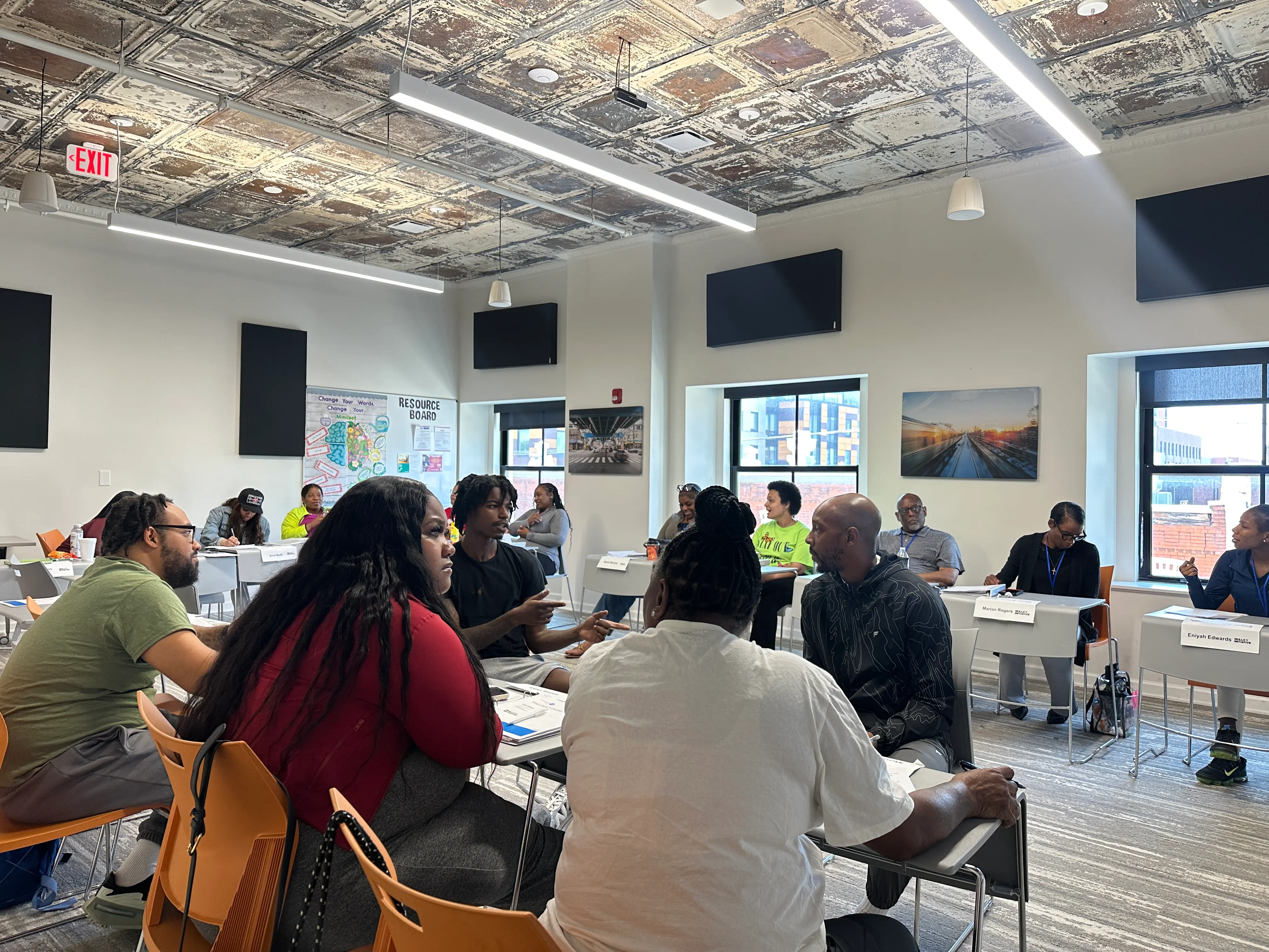 Group of adults seated in a classroom-style setting engaging in discussion during a workshop.