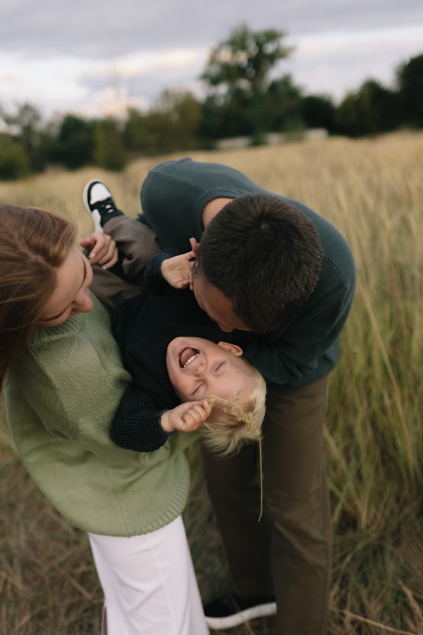 Family playing together in a grassy field.