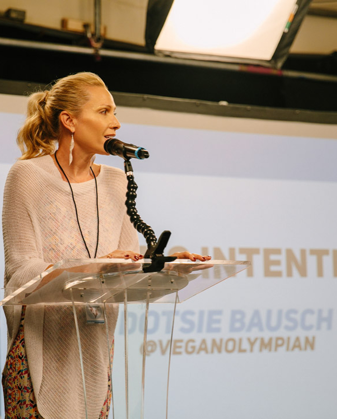 Dotsie Bausch speaking at a clear lectern