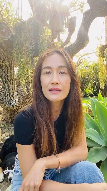 Maggie Q speaking outdoors in a garden