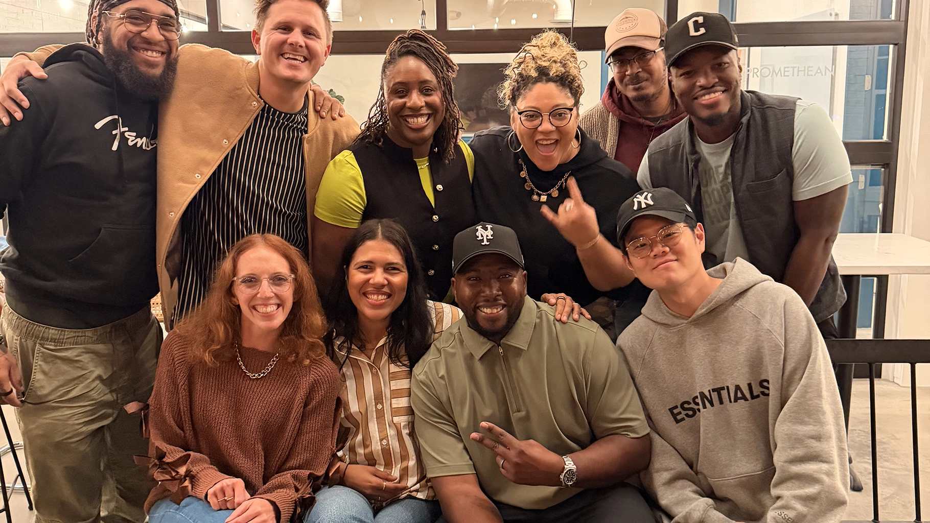 Group of diverse friends smiling and posing closely together indoors.