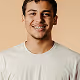 Smiling young man with short dark hair wearing a light gray t-shirt against a beige background.