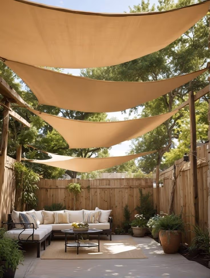 Cottage-style backyard with multiple cedar raised garden beds overflowing with colorful flowers and vegetables, a gravel and stepping stone pathway, and a small seating area near a wood gate in the background.
