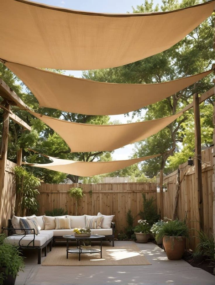 Cottage-style backyard with multiple cedar raised garden beds overflowing with colorful flowers and vegetables, a gravel and stepping stone pathway, and a small seating area near a wood gate in the background.