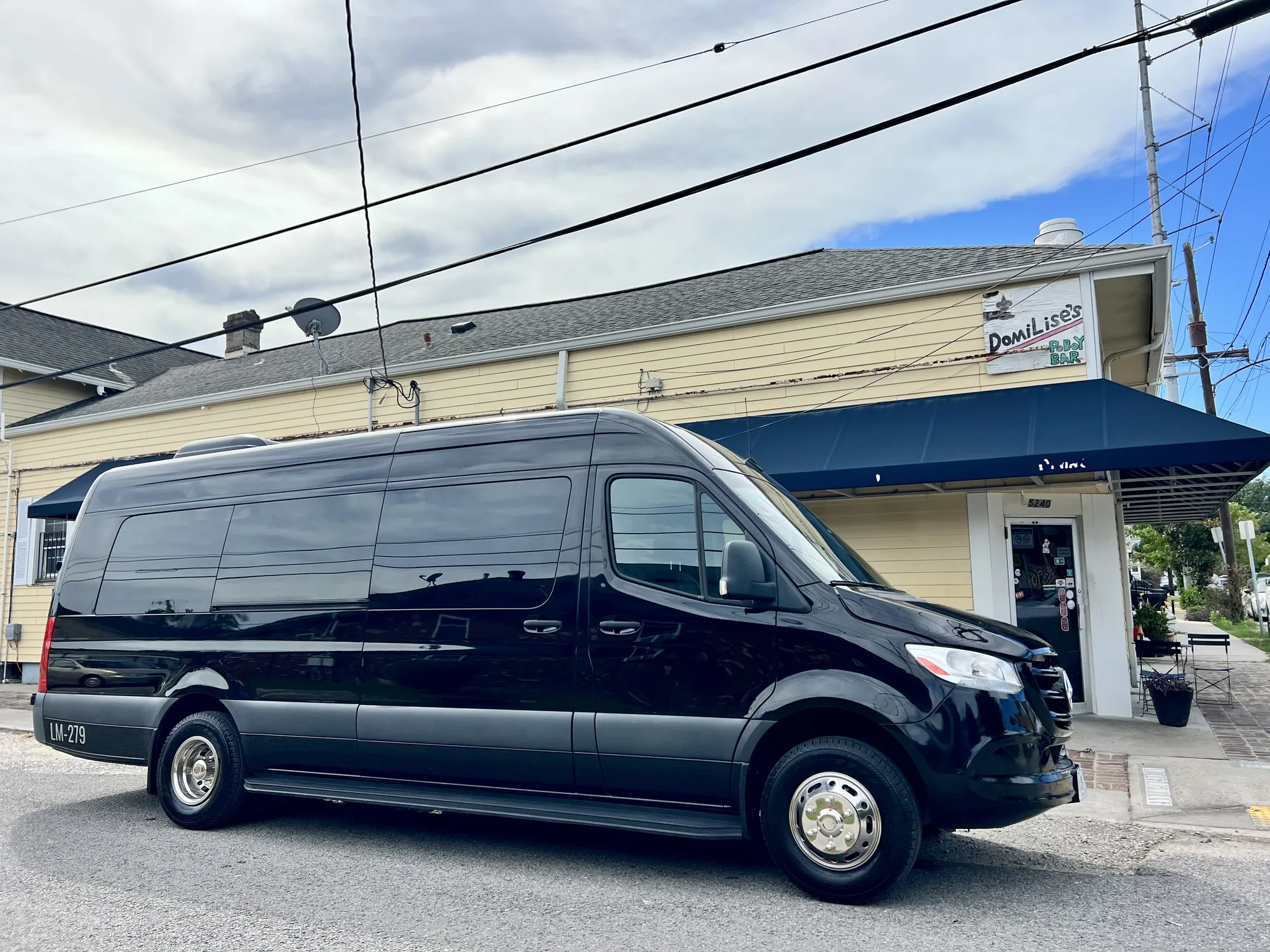 Black Mercedes Sprinter van outside a restaurant on an Uptown New Orleans street corner