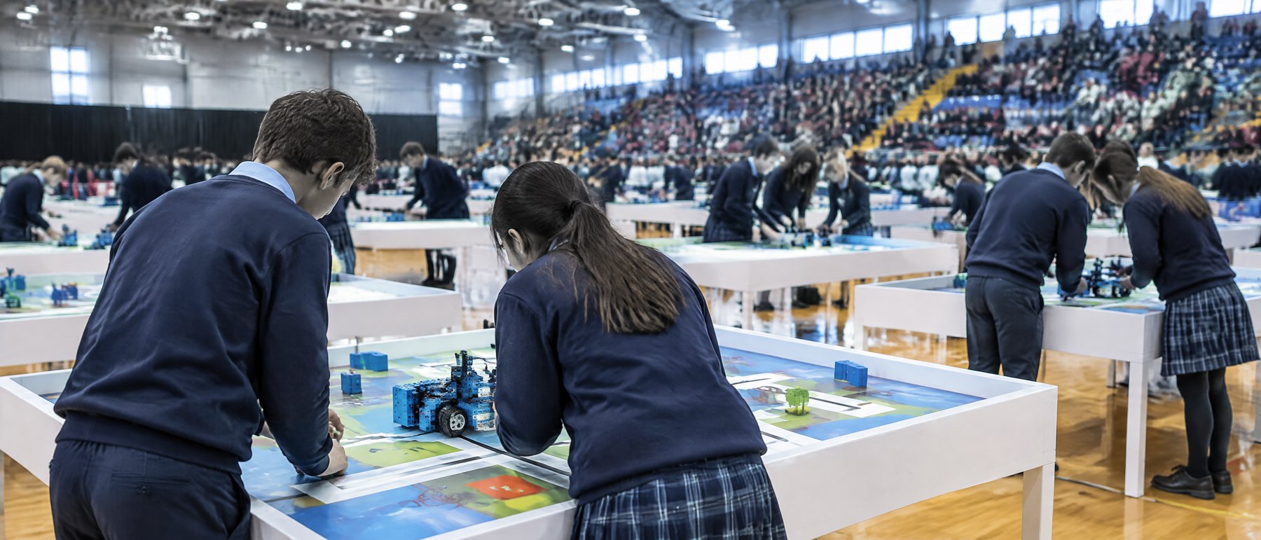 Equipos de alumnos en la arena de un torneo de robótica