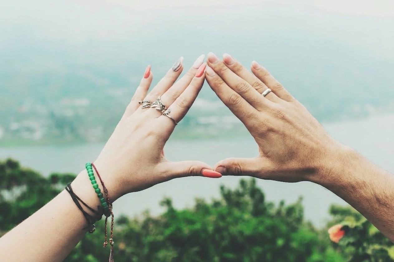 Deux mains en forme de triangle qui représente le triangle Sternberg. Illium l'application de l'amour pour les célibataires et les couples.